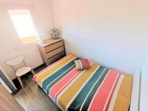 niewielka sypialnia z łóżkiem i krzesłem w obiekcie Résidence Le Cezelly - 2 Pièces cabine 5 couchages PORT LEUCATE. Réf: 4CEZ_6C MAE-6634 w mieście Port Leucate