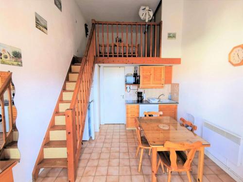- une cuisine et une salle à manger avec une table en bois et des escaliers dans l'établissement Résidence Grande Bleue - VILLA T1 CAB MEZZ 4 couchages PORT LEUCATE MAE-5944, à Leucate