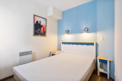 - une chambre avec un lit blanc et 2 tables dans l'établissement Résidence Cap Azur - maeva Home - Appartement 2 pièces 5 personnes - Confort MAE-4229, à Fouesnant