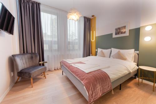 a hotel room with a bed and a chair at Stil Old Town Boutique Hotel in Bucharest