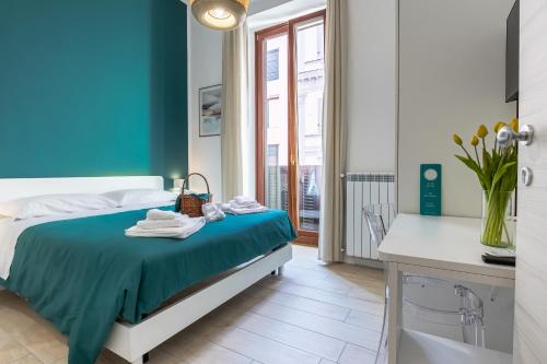 a bedroom with a bed with a blue wall at RUA DE MAR CHIATAMONE in Naples