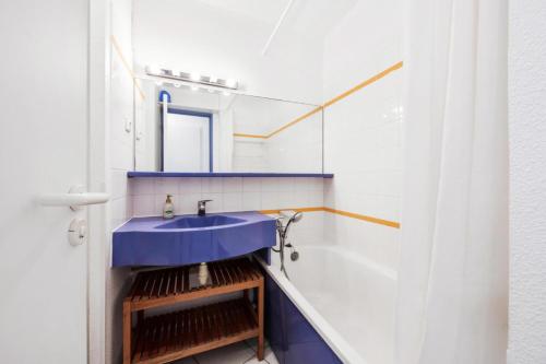 une salle de bain avec un lavabo bleu et un miroir dans l'établissement Résidence La Pinède - maeva Home - Appartement 3 Pièces 6 Personnes - Sélection MAE-4231, à Hyères