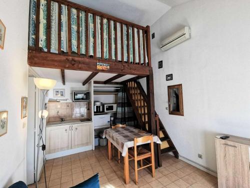 une cuisine avec un escalier et une table dans une pièce dans l'établissement Résidence Village Merlin - VILLA T2 MEZZANINE 5 couchages PORT LEUCATE MAE-5824, à Leucate
