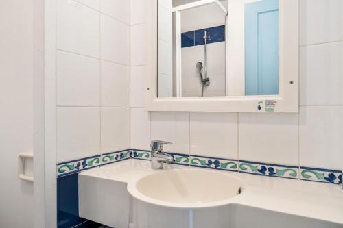 une salle de bain avec un lavabo et un miroir dans l'établissement Résidence Cap Azur - maeva Home - Appartement 3 Pièces 7 Personnes - Confort MAE-4376, à Fouesnant