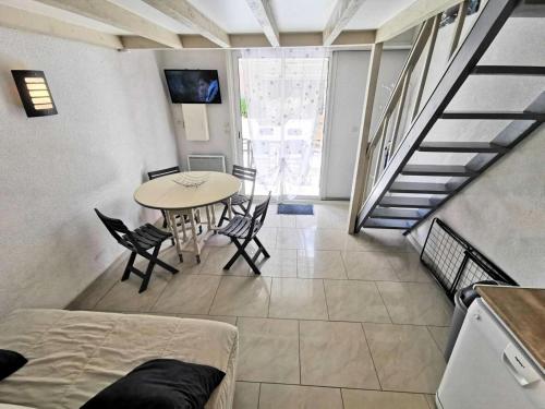 un salon avec une table et des chaises et un escalier dans l'établissement Résidence Grande Bleue - VILLA T1 CAB MEZZ 5 couchages PORT LEUCATE MAE-2394, à Leucate