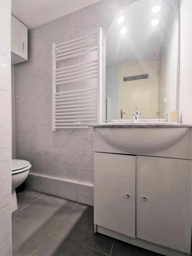 une salle de bain blanche avec un lavabo et des toilettes dans l'établissement Résidence Grande Bleue - VILLA T1 CAB MEZZ 5 couchages PORT LEUCATE MAE-2394, à Leucate