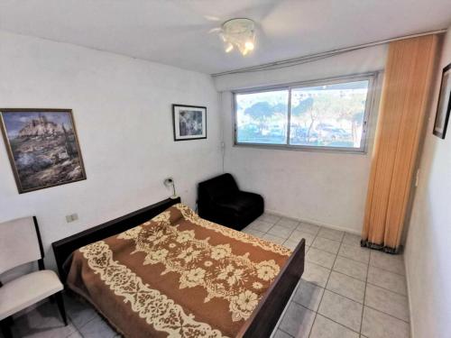 une chambre avec un lit, une chaise et une fenêtre dans l'établissement Résidence La Sardane - 2 Pièces 5 couchages LE BARCARES MAE-2404, au Barcarès