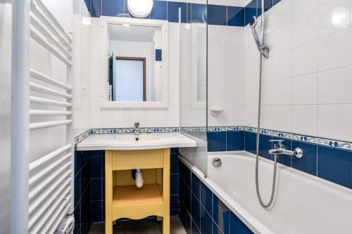 une salle de bain avec un lavabo, une baignoire et un miroir dans l'établissement Résidence Cap Azur - maeva Home - Appartement 3 Pièces 7 Personnes - Sélection MAE-4382, à Fouesnant