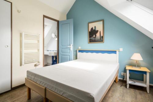 a bedroom with a large bed and a blue wall at Résidence Cap Azur - maeva Home - Appartement 2 Pièces 5 Personnes - Confort MAE-4387 in Fouesnant