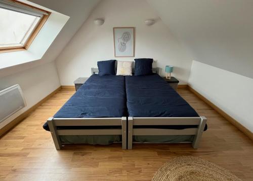 um quarto com uma cama grande e lençóis azuis em Maison de charme, proche plages em Saint-Pierre-Quiberon
