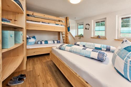 two bunk beds in a room with wooden floors at Ferienhaus Wendelhof in Eisenbach