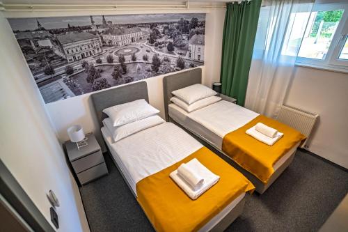 dwa łóżka w pokoju z obrazem na ścianie w obiekcie KM therooms BJELOVAR w mieście Bjelovar