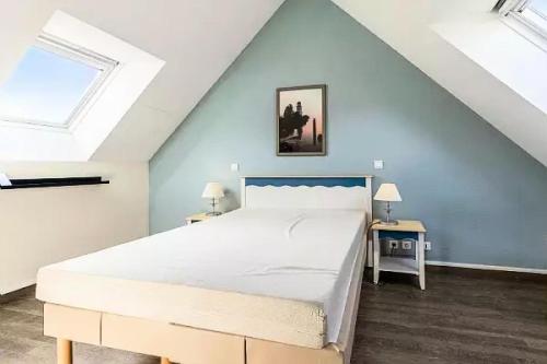 a bedroom with a large white bed in a attic at Résidence Cap Azur - maeva Home - Appartement 3 Pièces 7 Personnes - Sélection MAE-5087 in Fouesnant