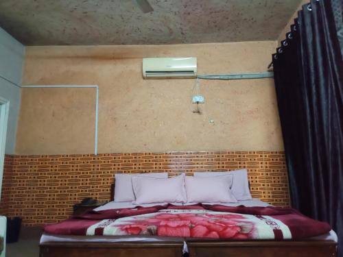 a bedroom with a bed with a brick wall at Zain Hotel Abbottabad in Abbottabad