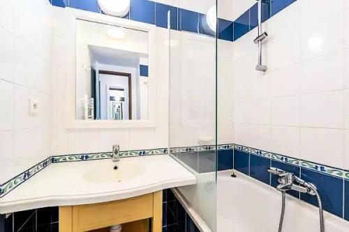 a bathroom with a sink and a tub and a mirror at Résidence Cap Azur - maeva Home - Appartement 3 Pièces 7 Personnes - Sélection MAE-5087 in Fouesnant