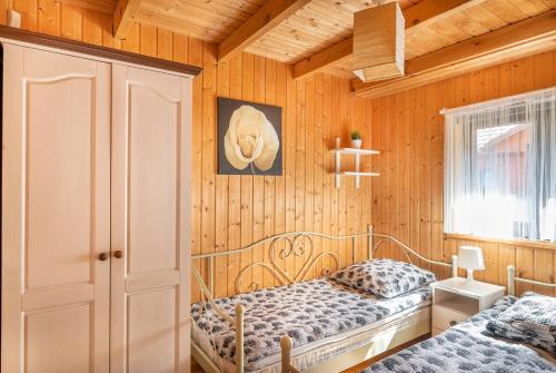 two beds in a room with wooden walls at Domki Hawana in Dąbki