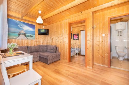 a living room with a couch and a bathroom at Domki Hawana in Dąbki