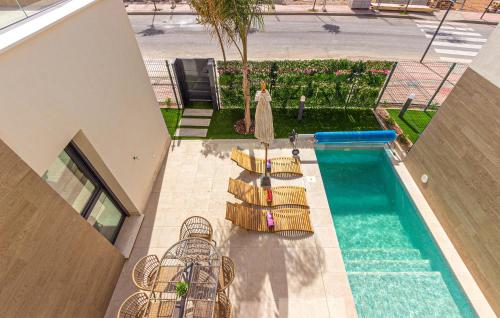 an overhead view of a swimming pool with chairs and a pool at 3 Bedroom Amazing Home In Torre Pacheco in Torre-Pacheco