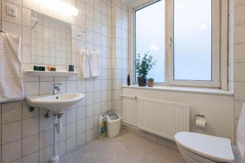 a bathroom with a sink and a toilet and a window at Hotel Maritime in Copenhagen