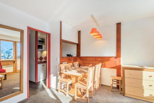 une cuisine et une salle à manger avec une table et des chaises dans l'établissement Résidence Les Fontaines Blanches - maeva Home - Appartement 2 pièces 7 personnes - Confort MAE-5103, à Morzine
