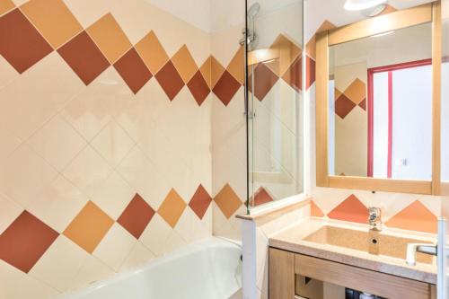 une salle de bain avec une baignoire et un lavabo dans l'établissement Résidence Les Fontaines Blanches - maeva Home - Appartement 2 pièces 7 personnes - Confort MAE-5103, à Morzine