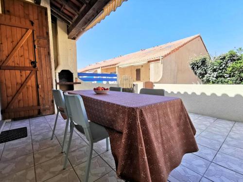 une table et des chaises assises sur une terrasse dans l'établissement Résidence Grande Bleue - VILLA T2 MEZZANINE 6 couchages PORT LEUCATE MAE-7294, à Leucate