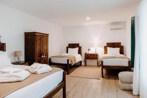 um quarto com duas camas e uma mesa com uma cadeira em Quinta do Louredo - Évora em Évora