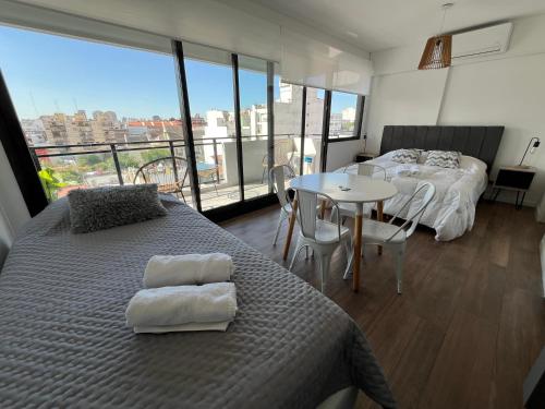 1 dormitorio con 2 camas y mesa con vistas en Torre Bóreas, tu viento a favor en Buenos Aires