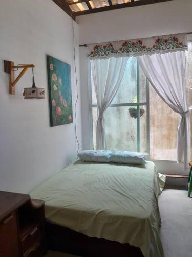 a bedroom with a bed and a window at Casa Charmosa Verde-Azul in Paracuru