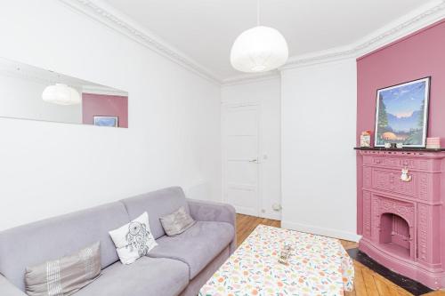 ein Wohnzimmer mit einem Sofa und einem rosa Kamin in der Unterkunft Charming Bright Apt In Paris in Paris