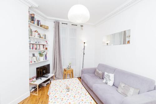 ein Wohnzimmer mit einem Sofa und einem Kamin in der Unterkunft Charming Bright Apt In Paris in Paris