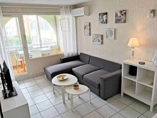 un salon avec un canapé et une table dans l'établissement Résidence Les Terrasses Du Port - 2 Pièces cabine 5 couchages PORT LEUCATE MAE-0474, à Leucate