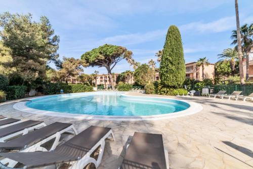 - une piscine avec chaises longues dans la cour dans l'établissement Résidence La Pinède - maeva Home - Appartement 2 Pièces 5 Personnes - Confort MAE-6327, à Hyères