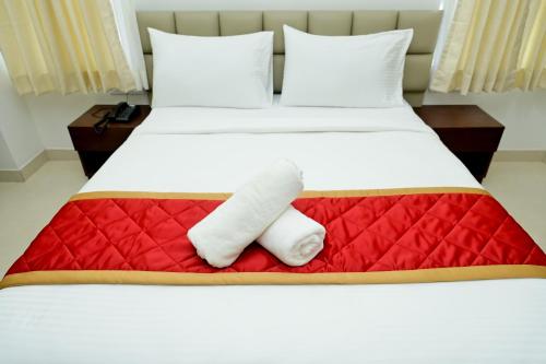 uma cama com duas toalhas em cima em The Mallika Sapphire em Chikmagalur