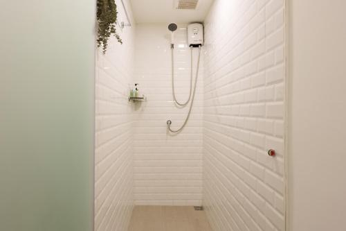 a bathroom with a shower with white tiles at t-t-haus in Bangkok