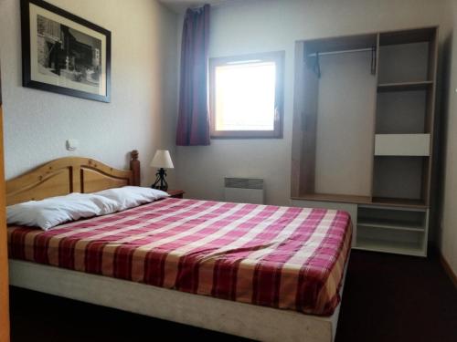 - une chambre avec un grand lit et une couverture rayée dans l'établissement Résidence Cristallines - 2 Pièces cabine 6 personnes MAE-0084, à Orcières