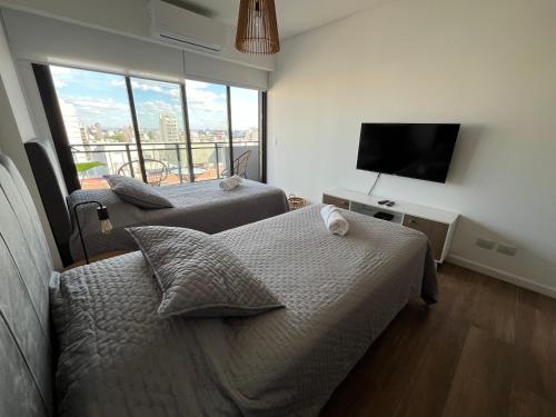 1 dormitorio con 2 camas y TV de pantalla plana en Boreas Tango en Buenos Aires