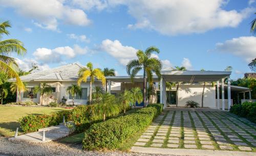 a house with palm trees and a driveway at Villa Bikini in Punta Cana