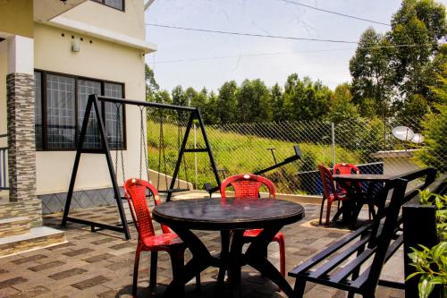 a patio with a table and chairs and a swing at Blue Lake in Kanthalloor
