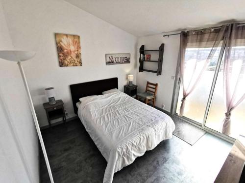 une chambre avec un lit et une grande fenêtre dans l'établissement Résidence Les Zodiaques - Appartement 3 Pièces climatisé 4 couchages PORT LEUCATE. Réf: 1ZOD_K5 MAE-6681, à Leucate