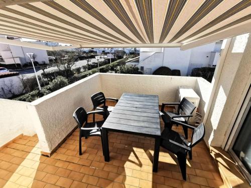 une table et des chaises sur un balcon avec vue dans l'établissement Résidence Les Zodiaques - Appartement 3 Pièces climatisé 4 couchages PORT LEUCATE. Réf: 1ZOD_K5 MAE-6681, à Leucate