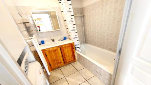 a bathroom with a sink and a tub and a mirror at Résidence Queyrettes - 2 Pièces pour 4 Personnes 134 in Puy-Saint-Vincent