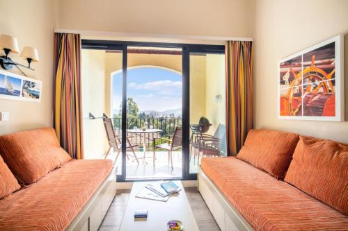 d'un salon avec un canapé et d'un balcon avec une table. dans l'établissement Résidence Les Parcs de Grimaud - maeva Home - Appartement 2 Pièces 5 Personnes - Confort MAE-6735, à Grimaud