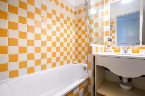 une salle de bain avec une baignoire et un lavabo et une baignoire tubermottermott dans l'établissement Résidence Les Parcs de Grimaud - maeva Home - Appartement 2 Pièces 5 Personnes - Confort MAE-6735, à Grimaud