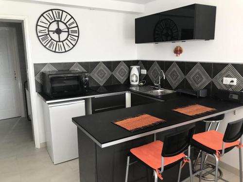 uma cozinha com um balcão e um relógio na parede em Résidence Superbellevue - 2 Pièces pour 2 Personnes 574 em La Madrague