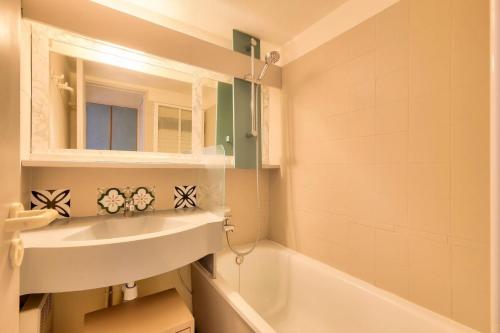 une salle de bain avec un lavabo et une baignoire dans l'établissement Résidence le Hameau de Cap Esterel - maeva Home - Appartement 2 Pièces 5 Personnes - Confort MAE-6795, à Saint-Raphaël