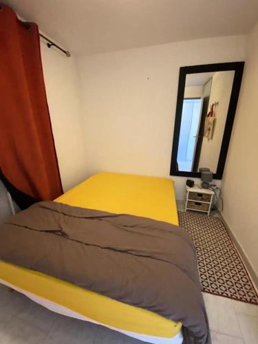 - une chambre avec un lit jaune et un miroir dans l'établissement Résidence Port Helena Coudouliere - Appartement front de mer MAE-7644, à Six-Fours-les-Plages