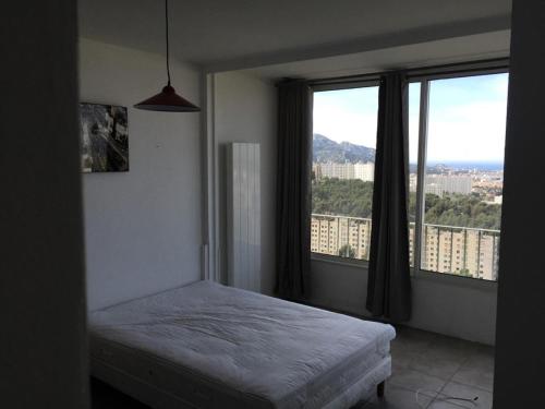 um quarto com uma cama e 2 janelas grandes em Résidence La Rouviere - 5 Pièces pour 8 Personnes 664 em Marselha