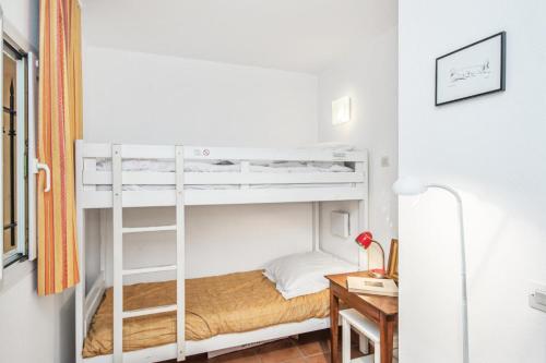 une chambre avec deux lits superposés et un bureau dans l'établissement Village Pont Royal en Provence - maeva Home - Studio climatisé 4 Personnes - Sélection MAE-7498, à Mallemort
