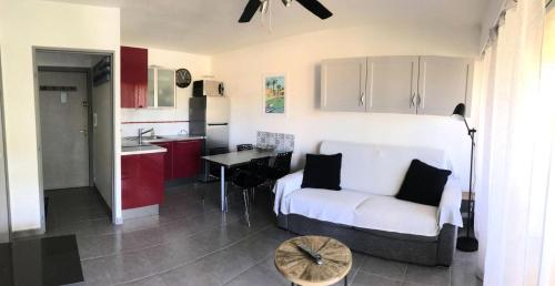 sala de estar con sofá blanco y cocina en Résidence Jardins Du Soleil - 2 Pièces pour 4 Personnes 754, en Six-Fours-les-Plages